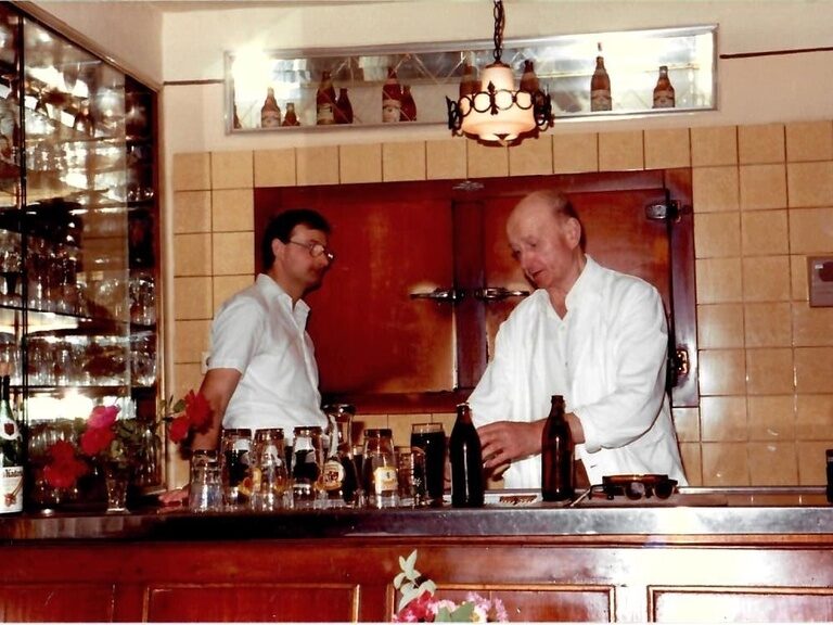 Eine sehr alte Aufnahme die zwei Köche in der Küche des Hotels Happinger Hof in Rosenheim zeigt.